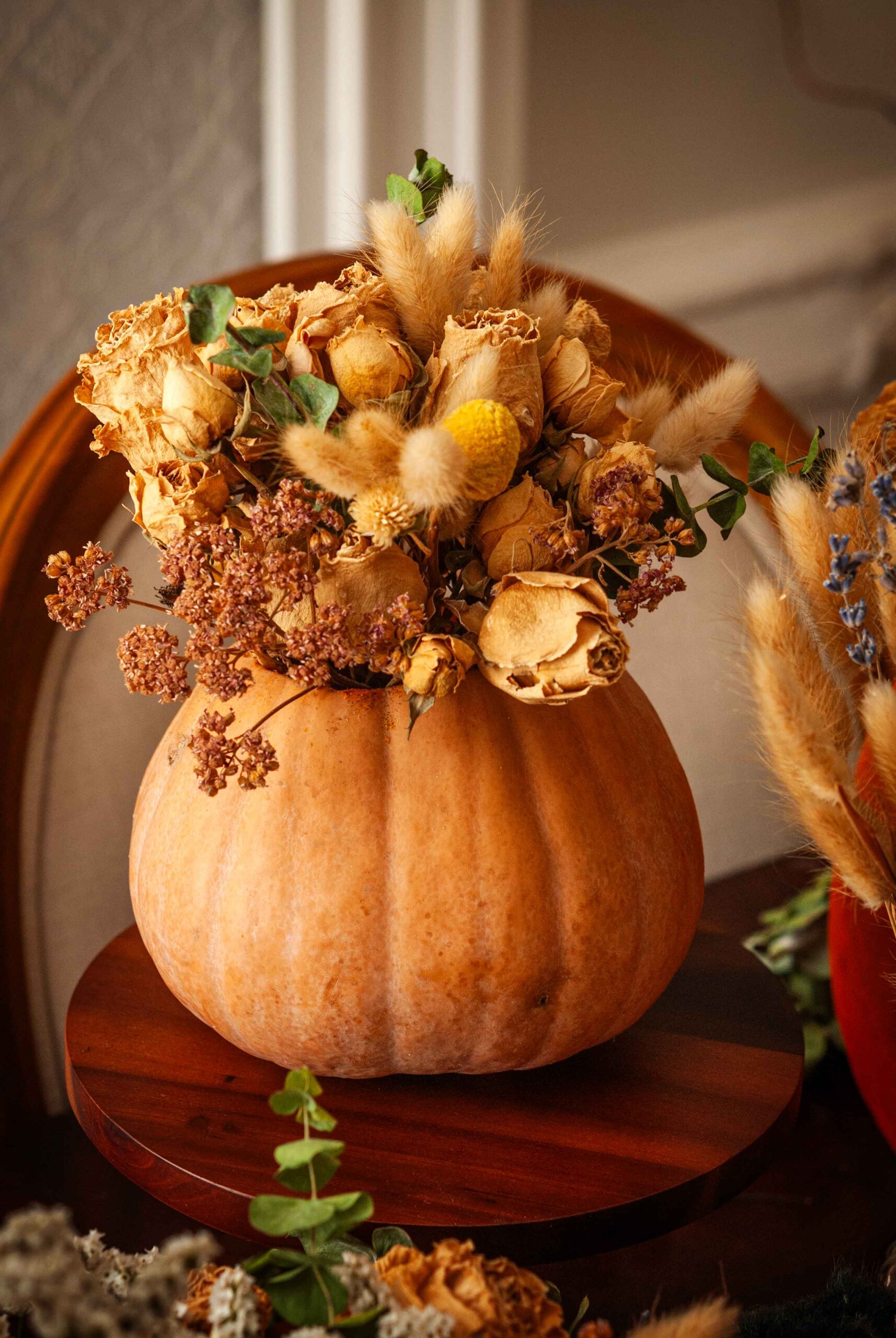 A pumpkin bouquet on a small cake stand.