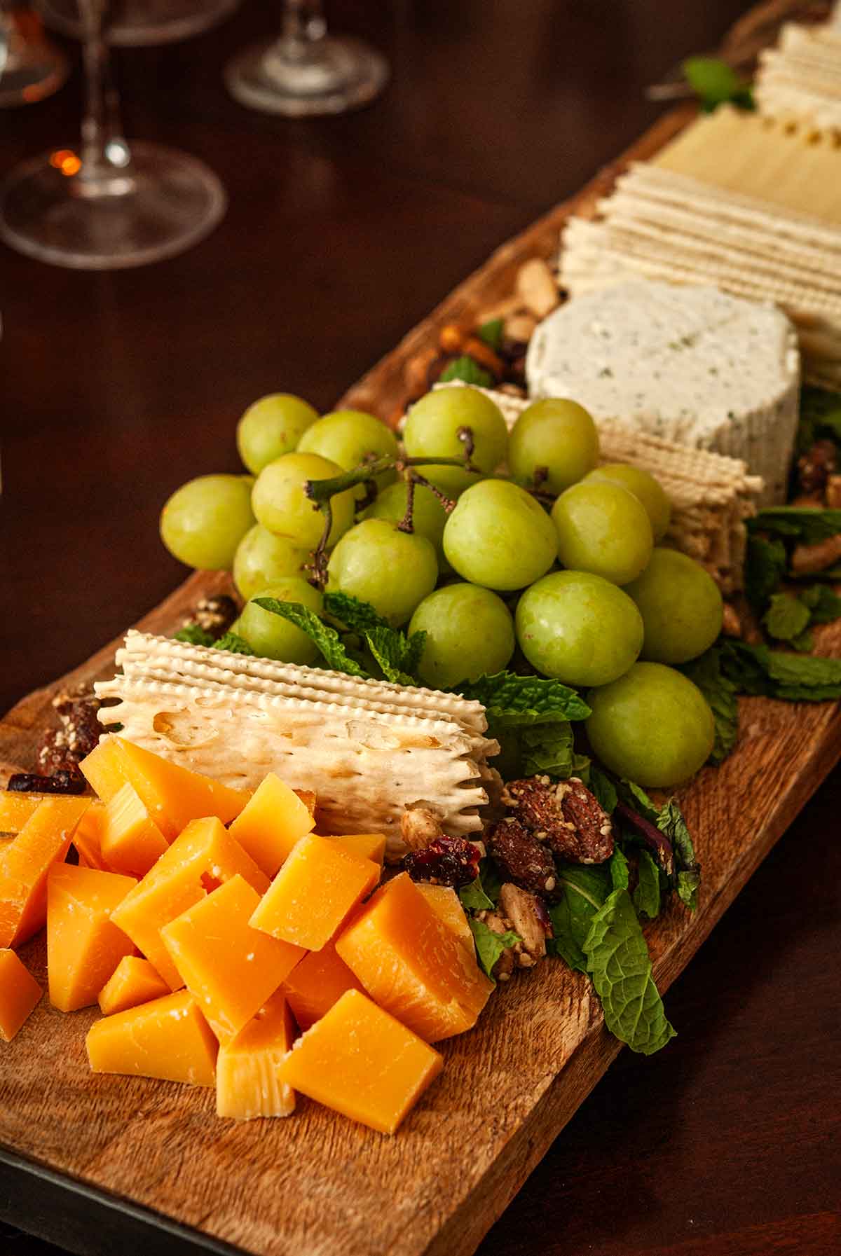 Cheese, grapes and crackers on a cheese board.