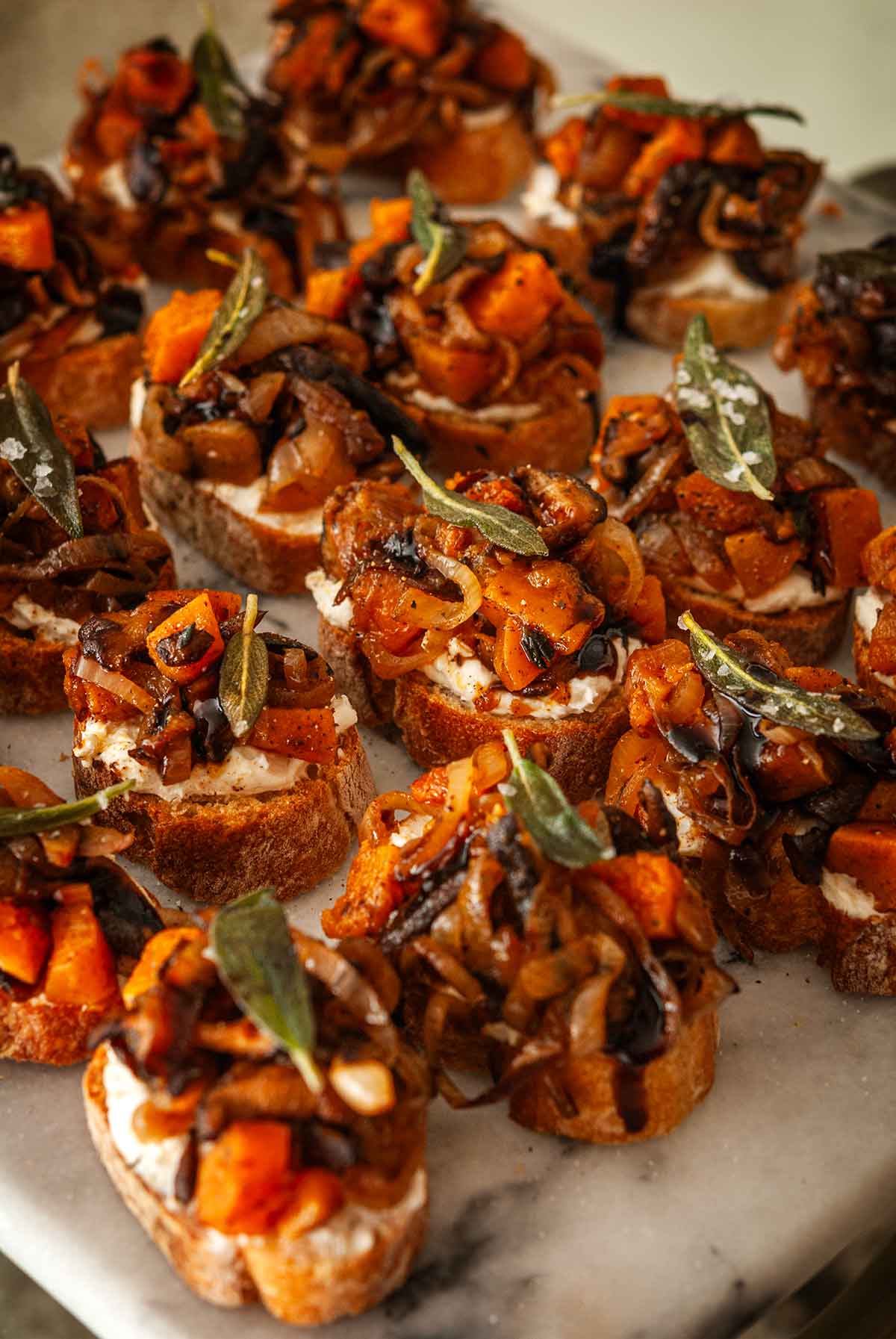 Small butternut squash appetizers on a marble slate.