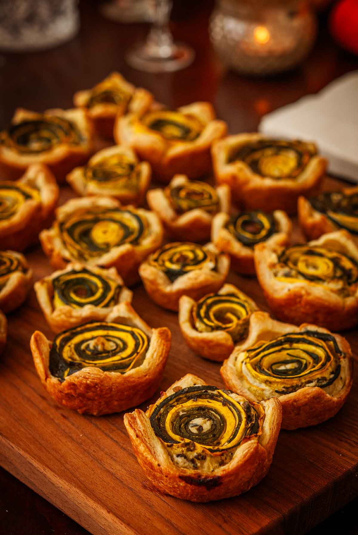 Pesto squash rosettes on a wooden board.